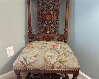 Intricately carved side chair, with carved stretcher and updated floral fabric.