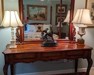 Vintage, 3-drawer Frenchy console table with bronze greyhound statue, marble table lamp, Old Paris table lamp and hand-carved mahogany mirror, with beveled edge.