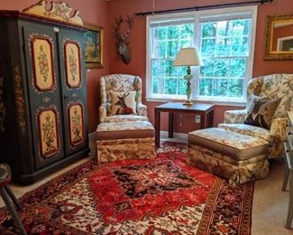 Sitting room with pair of freshly upholstered wingback chairs, with matching ottomans, faux ostrich skin table, hand-painted German armoire and Persian Heriz rug.