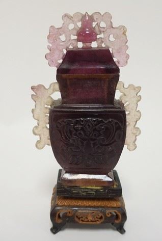 1007	CARVED AMETHYST STONE URN MOUNTED ON A CARVED WOODEN BASE, 6 1/4 IN HIGH
