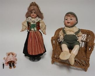 1065	GROUP OF THREE BISQUE HEAD DOLLS, ONE IS MINIATURE W/ A WOODEN BODY (5 IN H) A GIRL DOLL W STAND & A BOY DOLL W/ DOLL ARMCHAIR SIGNED MB JAPAN
