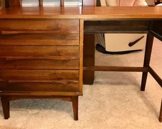 PRICE: $120.00  MCM Walnut Desk, Concave and Flared linear drawer handles. Price reflects MISSING desk drawer. Please see photos. IF we find the drawer as we go thru the house, we will contact purchaser. Looks like Young Manufacturing but find no manufac mark to verify. 
Measures: 48”Long • 31”Tall •18.5”Deep
Item#