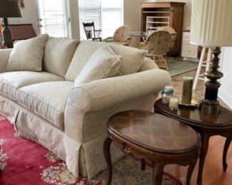 beautiful white  Damask upholstered sofa with butler style arms, gorgeous pair of oval End tables with a lattice look design on top  