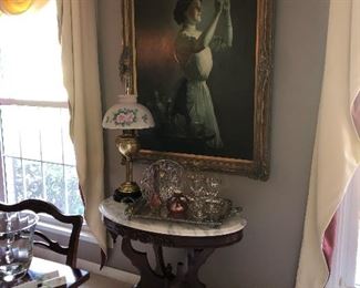 Original painting of lady checking glass quality, oval mahogany table with Italian marble top, by Kimbal furniture company