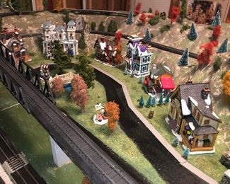 H O Scale Train village with four tracks and utilized Christmas village buildings, has street scenes and four tracks