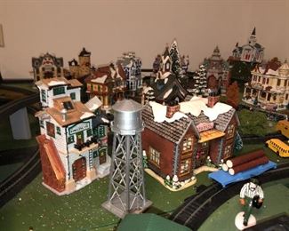 H O scale Train village with four tracks and utilized Christmas village buildings, has street scenes and four tracks