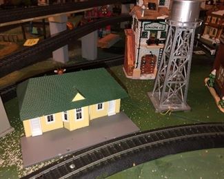 H O Train village with four tracks and utilized Christmas village buildings, has street scenes and four tracks