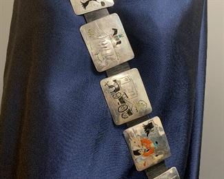 Staffs choice in the top 10, Story teller inlay belt by Benjamin Becenti, Dine ( Navajo). We love this concho belt, each concho with a different science of Navajo life. For example: a Navajo women weaving, a wagon with a adobe building, and with the words, "Trading Post", Navajo hogan, Native American man on galloping horse, Native American person on mesa overlooking sheep, and more. Don't miss this chance to own a masterpiece.