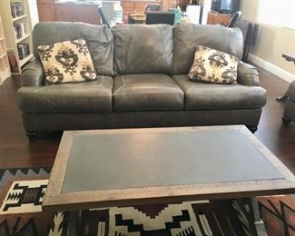 Sleeper sofa, coffee table and machine made 5' 5" x 7' 7" rug.