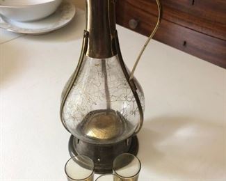 Glass/brass musical decanter and 3 shot glasses. Plays "How Dry I Am" when picked up. $40