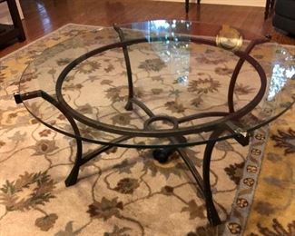 Glass-topped bronze metal coffee table $150; wool rug $50
