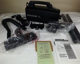 Unused Oreck compact vacuum. Box opened, accessories factory sealed. Item has not been tested.