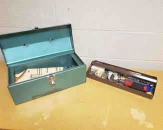 green metal tool box with tool tray. also included are all the tools in the toolbox. are miscellaneous wrenches box cutters screwdrivers and sockets. tool boxes approximately 16 in by 7 in