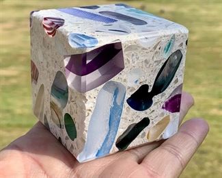 'Tectonic Cube' by Paul Harrie, comprised of various pieces of glass cane, chips and murrini embedded in a concrete resin matrix. The surface is nicely ground and polished. The cube rests securely in its own custom made glass stand. Each edge is 2 1/4" across: $150