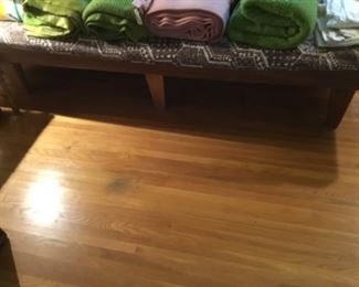 Bedding and linens are on this vintage platform bed - this is a side view of the bed.