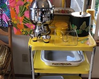Yellow metal kitchen cart with outlet, Hamilton Beach coffee urn, cute apron (one of many), Georges Briard ice bucket, Corning Ware lasagna pans, cute tin trays