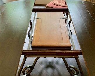 Detail: French country wrought iron base, wooden topped table with self storing collapsible leaf