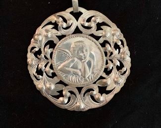 $65 Sterling silver round filigree pendant with angel motif.  Approx 3" diameter.  Reverse marked 925.
