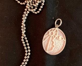 $110 Guayasamin for Taller (Mexico) Modernist sterling silver pendant and silver tone beaded chain. Oval pendant has a face looking at the sun in relief. Reverse signed