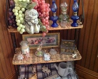 Metal and rattan shelving unit, mini oil lamps, angel bowl with grapes, small fruit print-framed