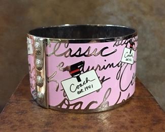 Cute collectible Coach pink bangle bracelet. 1 1/2" wide and 7 3/4" inner circumference.  Coach logo and Coach est. 1941 stamped inside.  $60 
