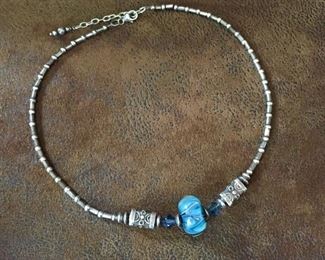Boho Sterling silver necklace with a gorgeous blue art glass focal bead, accented by blue Swarovski crystals, sterling rondelles and fantastic triangular silver Bali barrel beads.   Adjustable length from 18" to 20".  $140
