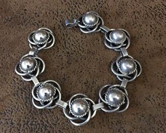 7 1/2" mid-century Mexico silver link bracelet.  Each of the eight links have solid silver centers with heavy gauge silver wire decoration.  Stamped SILVER MEXICO on the hook clasp.  $200
