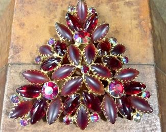 Lovely 3" wide vintage brooch with a unique combination of mostly smooth stones (some shiny, some with a satiny surface) and just a sprinkling of sparkly cherry red faceted rhinestones for that special highlight of bling.  $80
