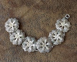 Pretty 7 3/4" silver filigree bracelet with six flower-shaped links.  Very vintage. $80
