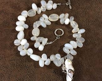 Artisan-made 18" necklace with pebble-shaped agate beads and featuring a Sterling silver wire wrapped pearl pendant.  $130

