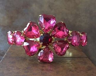 Fabulous vintage clamper cuff bracelet, featuring heart-shaped fuschia pink rhinestones forming a flower with a cherry red rhinestone center. Hinged in the back, opens in center front. Circumference is 6 3/4". $126