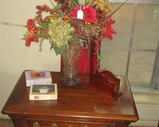 Side table, note cards, decorative floral arrangement.