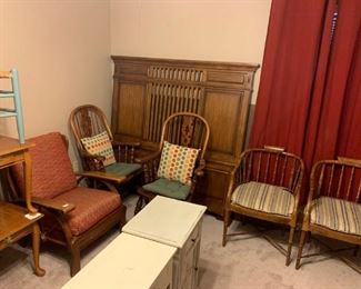 Front Bedroom: Wagon wheel chair, four office chairs, queen size bed, white six drawer chest, cute stand with a fleur de lis  design on the door