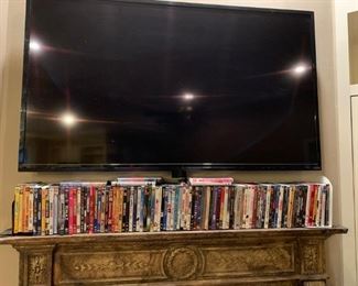 Den: Mantle full of DVDs.  Smart TV and stand.