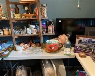 Master Bedroom: Small flat screen TV, huge assortment of creamers, glassware, tins, copper molds, china dolls, cold drink bottles, more  comforters and electric blankets on floor.