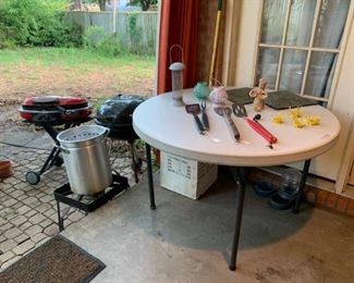 Back Porch: Table full of grilling utensils, tea lights, decorative wall art, Turkey Fryer, two BBQ grills