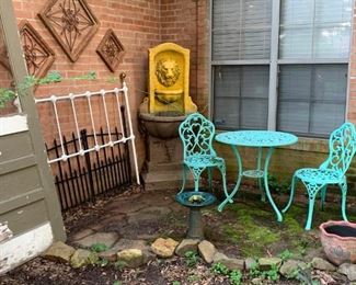 Front Entrance:  More outdoor decorations.  An old door, headboard, metal and wood wall art, garden gates, Lion head fountain, three piece table set, bird bath, flower pot.  Not pictured, old wooden school desk, broken tile mosaic decorated top flower stand, birdfeeder on a pole, shepherds hook.