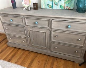 $350 - Gray faux-painted seven-drawer/one-door dresser with ceramic knobs; measures 18" deep, 69" wide, 36" high.