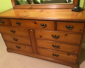 $250 - Close-up of nine-drawer, pine dresser with matching mirror;  dresser measures 20" deep, 58" wide, 33.5" tall; mirror measures 49" wide, .5"34 tall.