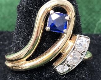 Jewelry 15: 14k Diamond and Sapphire Ring $575
Two-tone 14kt gold set with three Old Mine Cut diamonds, and one square cut blue sapphire. The diamonds weigh .09ct each, estimated total weight or .27ct of H-I color and S12 clarity. The synthetic sapphire measures 4mm in size. The mounting is a cast style with the sapphire prong set in a swirl and the diamonds are bed prong set into a white gold applied plate. 2.7dtw