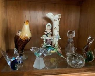Lot 119-lot of glass animal figurines - blue and green bird $10, tall glass brown bird $15, clear crystal bird $15, glass dolphin $20    Lot 120- lady with flowers $15, glass round paper weight $8, Murano glass cat $35,   glass cat red and green $15  Red/green cat sold