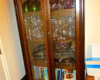 Display cabinet with internal lights. Lots of crystal goblets and silver