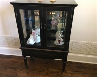 Item:   Bombay Small Display cabinet
Condition:  Excellent   
Measurements: 28w x 13d x 43h
Description:  Small Bombay display cabinet having 2 doors on columnar legs having a glass shelf.  Painted leaf décor on top.

Price:  $175
