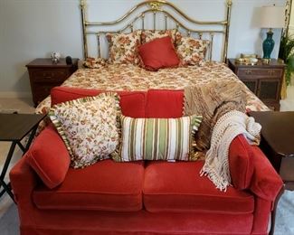 Kingsize brass headboard and a red corduroy upholstered settee 