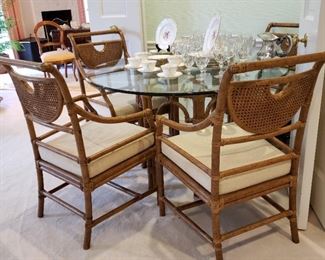 Rattan armchairs and round glass top table