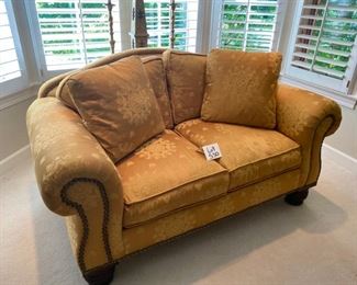 Lot 530.   $695.00  This is a marvelous Damask Upholstery Loveseat From Beacon Hill.  It is 66” long, 43” deep, with fab nailhead trim.  QUALITY MADE.  It may be down-filled, the color is warm and neutral gold and above all, comfy — perfect for a sitting room or a quiet nook for reading.  