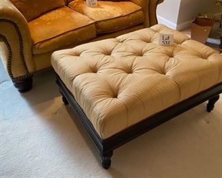 Lot 533.  $295.00  Gold Ottoman with tufted fabric upholstery and footed black legs.   So comfortable - use the leather tray (next lot) so it can function as a cocktail table.  Measures 41” wide. 29” deep, 18” high.  You know you are home when you put your feet up on this soothing piece of furniture. 