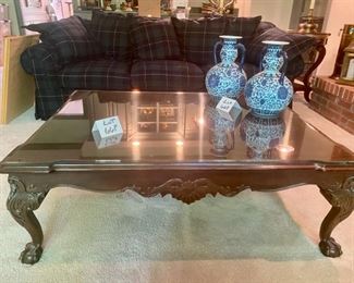 Lot 668. $475.00  Coffee table with custom glass top, ball, and claw feet. 41"x52"x17.5" tall.