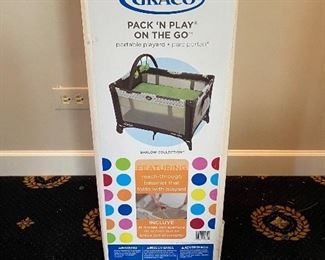 Lot 556. $65.00  Brand new in the box, Graco Pack' n Play, On the Go portable play yard, Brown Barlow Collection Graco's price is $99.99 for the same thing.