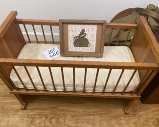 Lot 605. $38.00 Vintage wooden  doll crib 28"x14"x30"tall; with mattress.  Side goes up and down, and also we have included a cute needlework bunny in a frame. Great Shape.